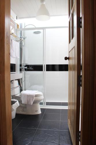 a bathroom with a glass shower and a toilet at At Residence Suvarnabhumi Hotel in Lat Krabang