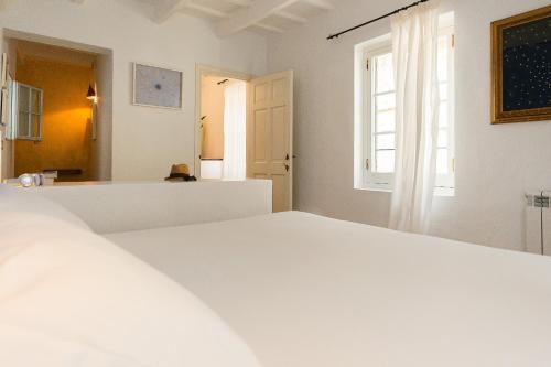a white bed in a room with a window at 971 Hotel Con Encanto in Ciutadella
