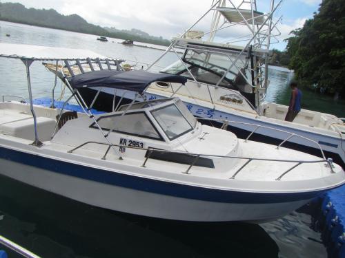 a white boat is docked in the water at Shell Villa apartel resort in Koror