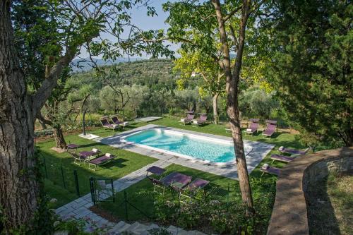 a swimming pool in a yard with chairs and trees at Villa Medicea di Lilliano in Grassina