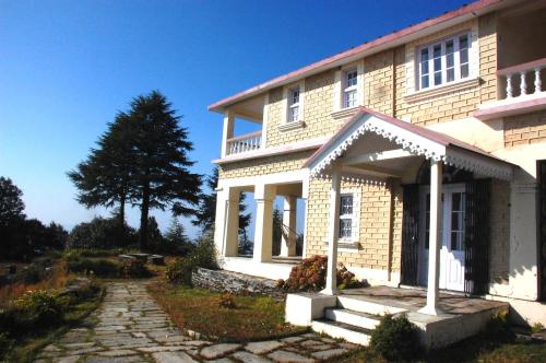 a house with a stone walkway in front of it at Tree of Life Grand Oak Manor Binsar in Binsar