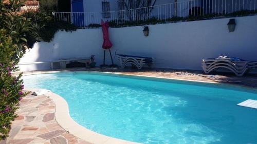 une piscine avec de l'eau bleue dans une cour dans l'établissement l'ecrin bleu, aux Issambres