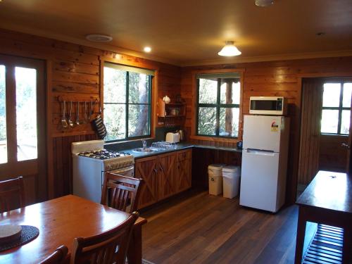 a kitchen with a white refrigerator and a table and chairs at Cradle Highlander in Cradle Mountain