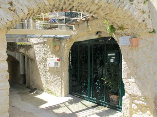 an entrance to a stone building with a green door at Cairenou Location in Saint-Martin-dʼArdèche
