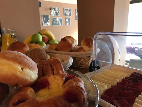 a table with a tray of pastries and a basket of fruit at Heartland City B&B in Tuzla