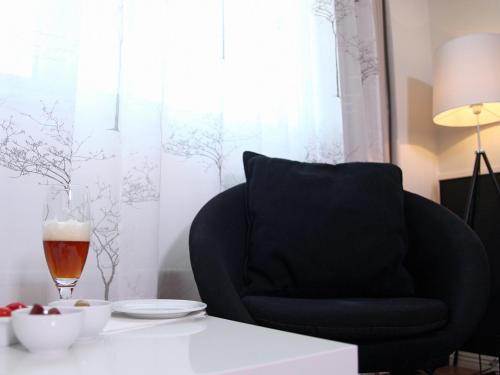 a black chair sitting next to a table with a glass of beer at Best Western Gustaf Froding Hotel & Konferens in Karlstad