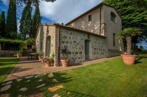 un edificio de piedra con macetas en un patio en Argiano Dimore Wine Relais, en Argiano