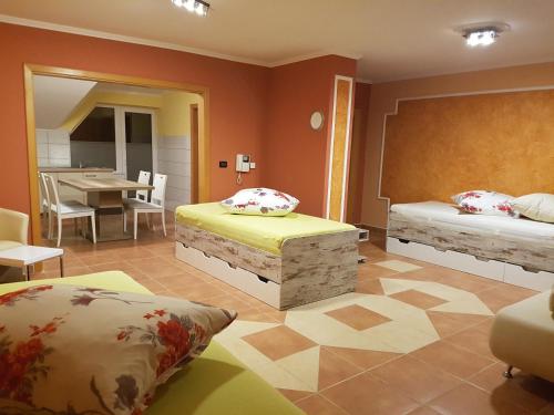 a bedroom with two beds and a dining room with a table at Apartments O Sole Mio in Vukovar