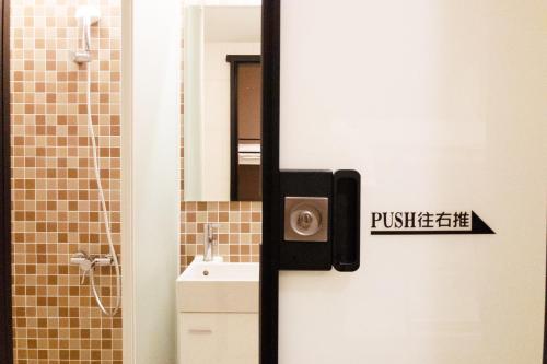 Un baño con una puerta con un cartel. en Divecube Hotel en Taichung
