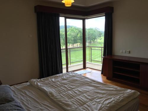 a bedroom with a bed and a large window at Ian's Vacation Rental in Skudai