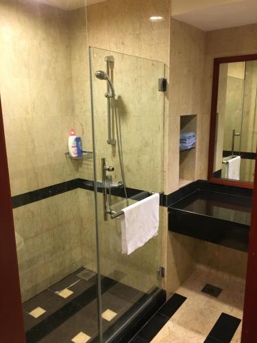 a shower with a glass door in a bathroom at Ian's Vacation Rental in Skudai