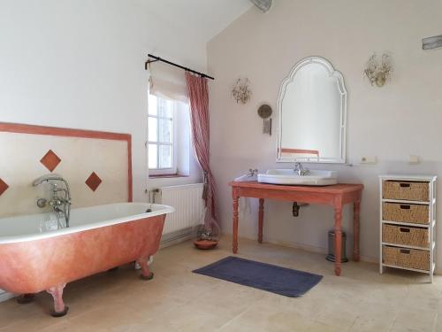 a bathroom with a large tub and a sink at Le Mas des Fleurs Séguret in Séguret