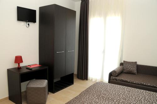 a living room with a black cabinet and a chair at Hotel Morena in Lido di Jesolo