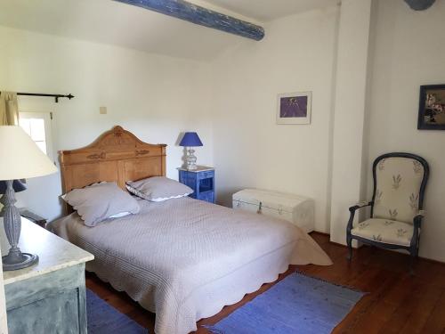 a bedroom with a bed and a chair at Villa GOHY in Séguret