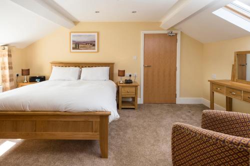 a bedroom with a large bed and two chairs at The Old Lodge in Malton