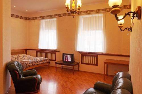 a living room with a couch and a bed and windows at Apartament Erfolg 8 in Daugavpils