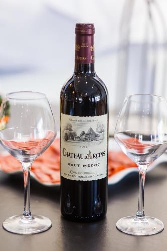 a bottle of wine next to two wine glasses at Hotel Plaza Biarritz Plage - Handwritten Collection in Biarritz