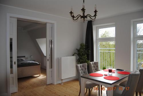 ein Esszimmer mit einem Tisch und Stühlen sowie ein Schlafzimmer in der Unterkunft Ruhige Ferienwohnung in der City Königswohnung in Kiel