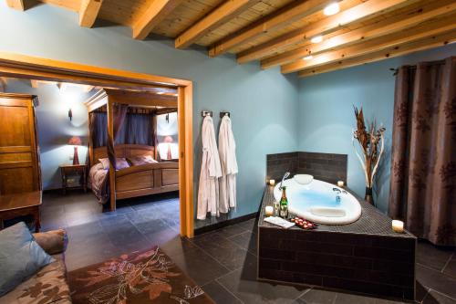 a bathroom with a bath tub and a bedroom at Castel Damandre - Demeures & Châteaux in Arbois