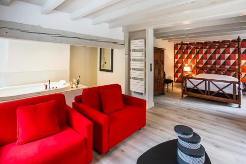 a living room with a red couch and a bedroom at Castel Damandre in Arbois