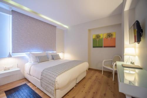 a bedroom with a white bed and a window at Calma Hotel & Spa in Kastoria