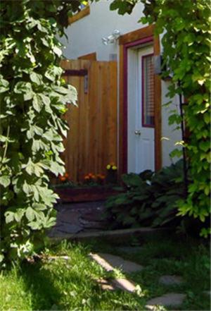 una casa con una puerta blanca y un arbusto en Charlie's Guesthouse, en Field