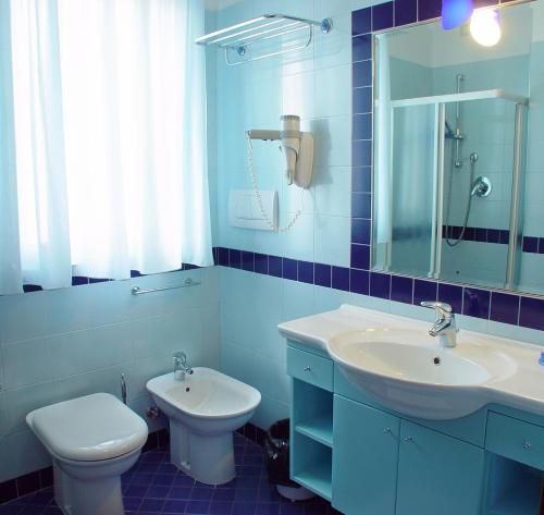 a blue bathroom with a sink and a toilet at Residence Oltremare in San Benedetto del Tronto