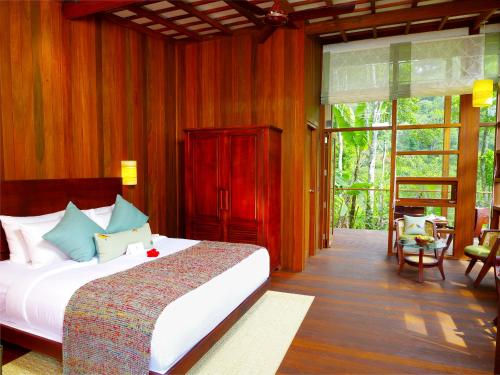 a bedroom with a large bed in a room at Niraamaya Retreats Cardamom Club in Thekkady
