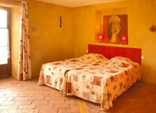 a bedroom with a bed and a painting on the wall at La Jameliniere in Chailland