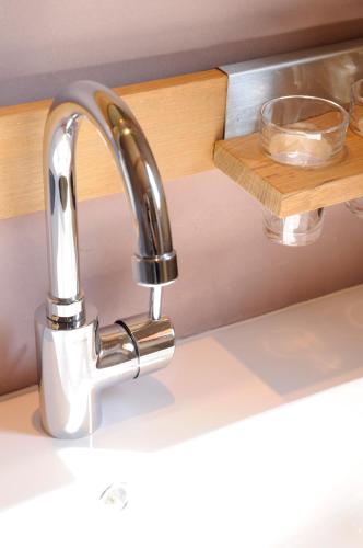 - un évier de cuisine avec un robinet en chrome dans l'établissement La Pierre Folle Chambres d'Hôtes, à Cluny
