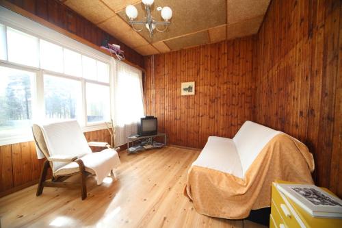 a bedroom with two chairs and a bed and a television at Annenhof Holiday House in Pudisoo