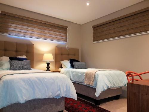 a bedroom with two beds and a window at Zimbali Suites 109 in Ballito