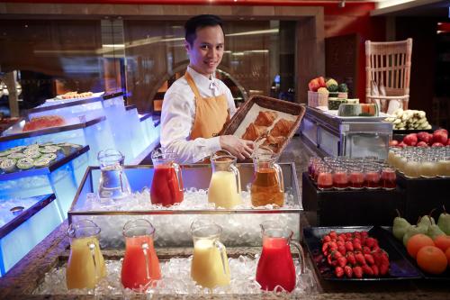 a man is preparing food in a kitchen at Kowloon Shangri-La, Hong Kong in Hong Kong