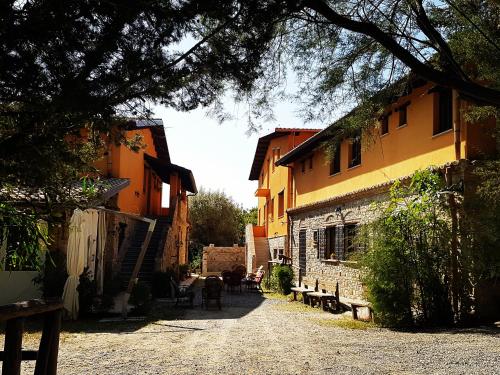 an alley with benches and a building and a tree at Agriturismo Feudo Gagliardi in Caulonia