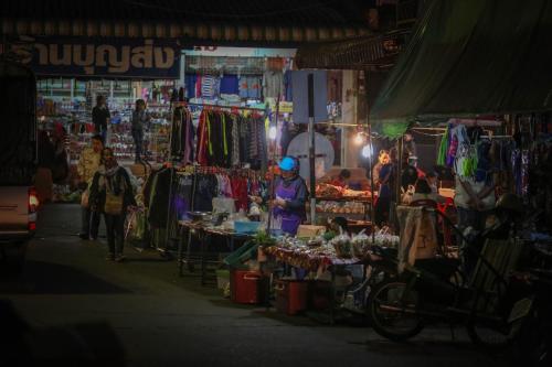 a woman standing in a market at night at โรงแรมนางรอง in Nang Rong