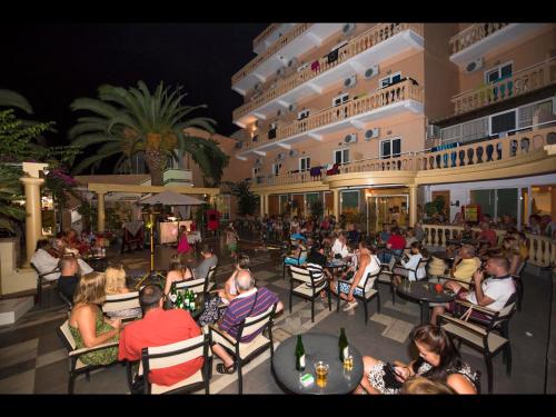 a group of people sitting in chairs outside of a building at Potamaki Beach Hotel in Benitses