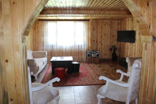 a living room with a couch and a table and chairs at Luka House in Akhaldaba