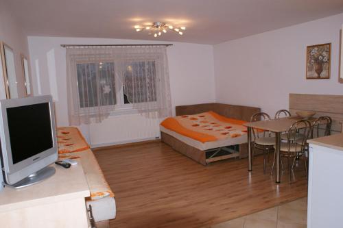 a bedroom with a bed and a table with a television at Willa Sara in Ustka