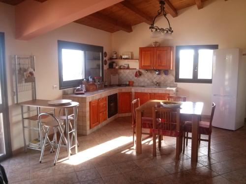 una cucina con armadi in legno, tavolo e sedie di Villa Nino a Marina di Ragusa