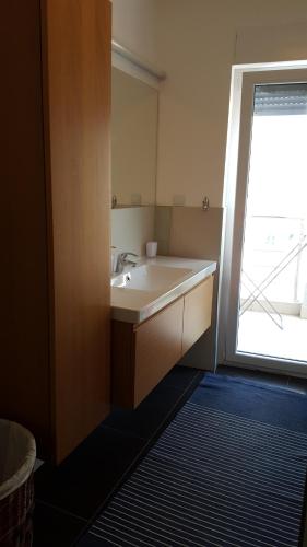 ein Badezimmer mit einem Waschbecken und einem großen Fenster in der Unterkunft Villa Dobre Vode in Dobra Voda