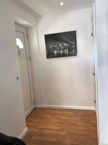 a room with a white wall with a picture on it at Rundvejen Guest House in Aalborg