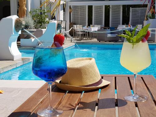 two drinks on a table next to a swimming pool at Hotel Orsa Maggiore in Anacapri