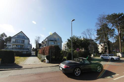 a green car is driving down a street at Ankerplatz Timmendorfer Strand in Timmendorfer Strand