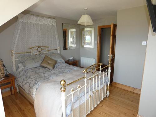 1 dormitorio con 1 cama blanca con dosel en Aghadoe View Bed & Breakfast, en Killarney