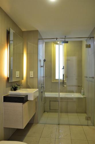 a bathroom with a shower and a sink and a tub at Holi Afiniti Themed Suites in Nusajaya