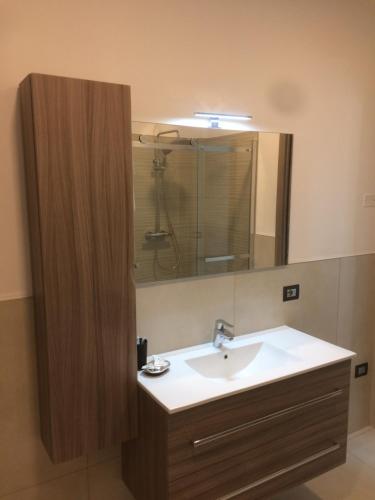 La salle de bains est pourvue d'un lavabo et d'un miroir. dans l'établissement Hotel La Pergola, à Moniga del Garda