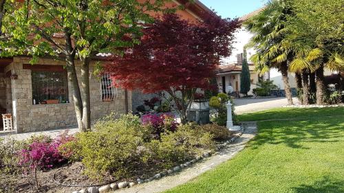 a house with trees and flowers in a yard at B&B Le Palme in Appiano Gentile