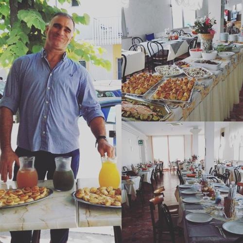a man standing in front of a table with plates of food at Hotel Ricci in Rimini