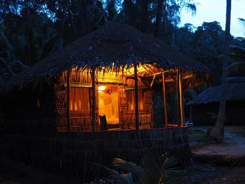 a small hut with a thatched roof at night at Rimba Resort - Dive Centre & Spa in Pulau Sibu