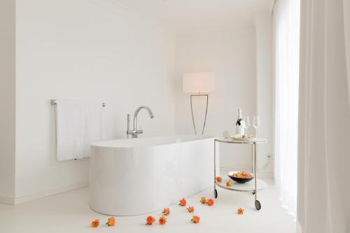 a white bathroom with a tub and a bowl of food at Hotel Villa Seeschau - Adults only in Meersburg